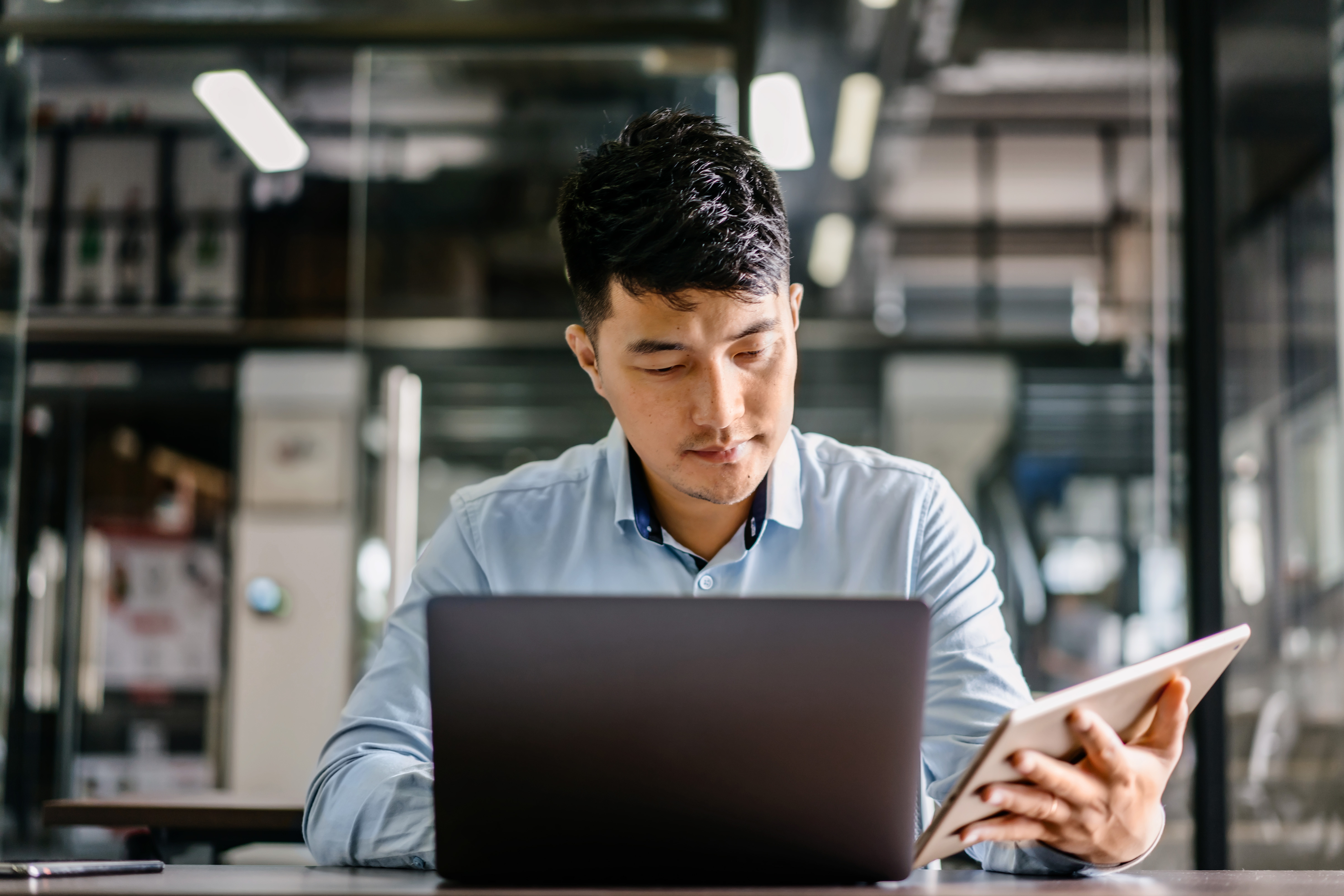 A man browsing on his laptop and tablet