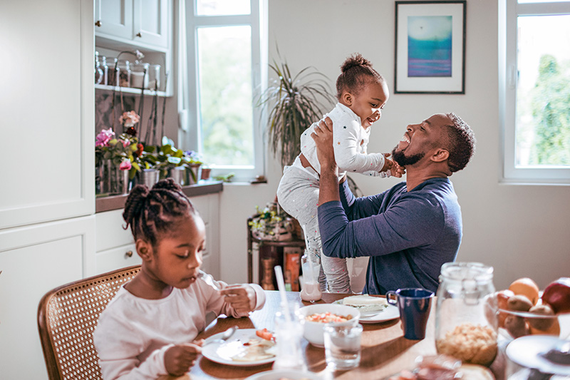 father and daughters at the table