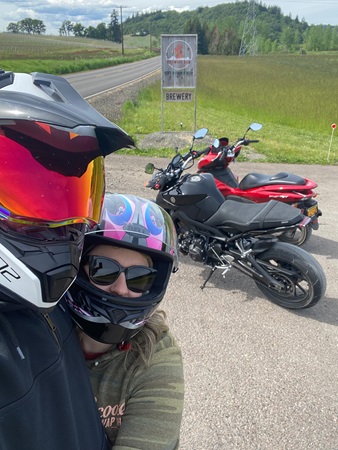 Couple pose in front of motorcycles outside