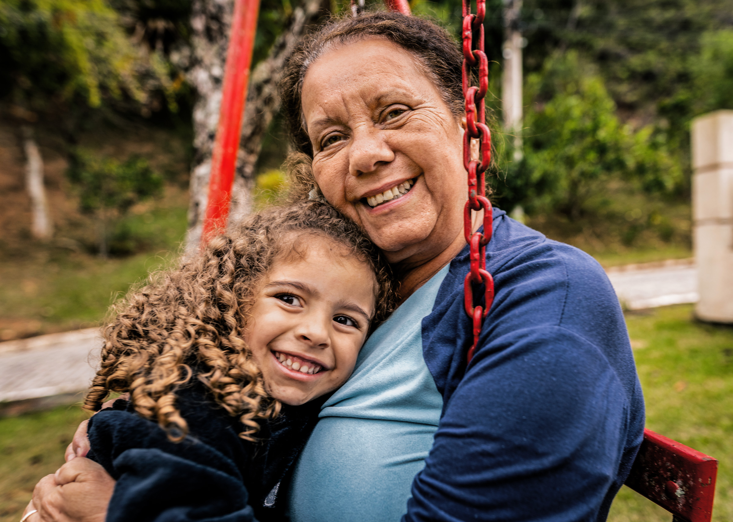 Mother and daughter smile on the swings
