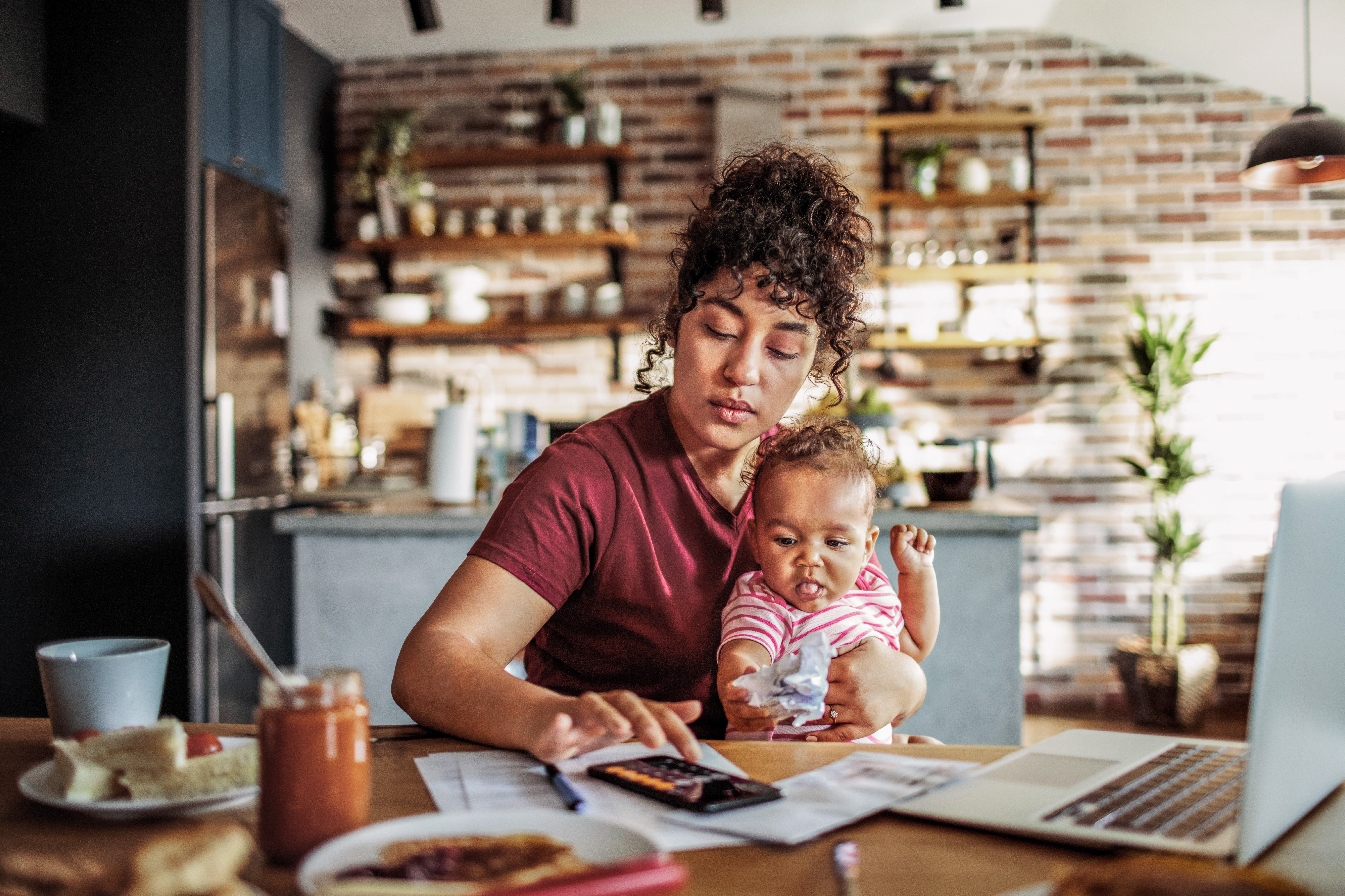 Mother works from home with a baby on her lap
