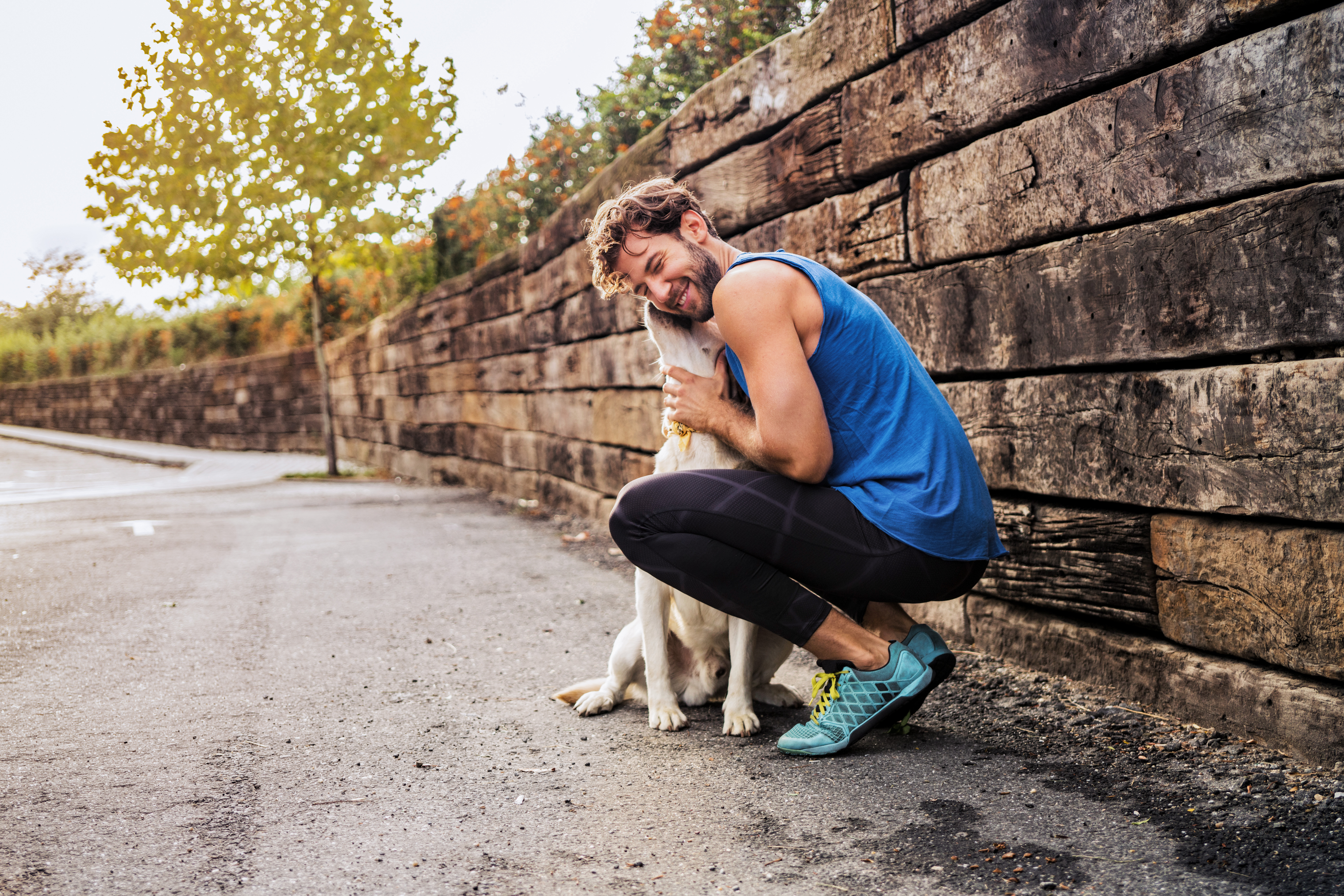 Man hugging his dog on a walk